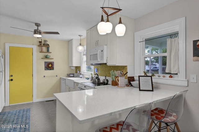 606 Ivey Cir, Wilmington, NC 28401 - kitchen with white microwave, healthy amount of natural light, backsplash, and hanging light fixtures