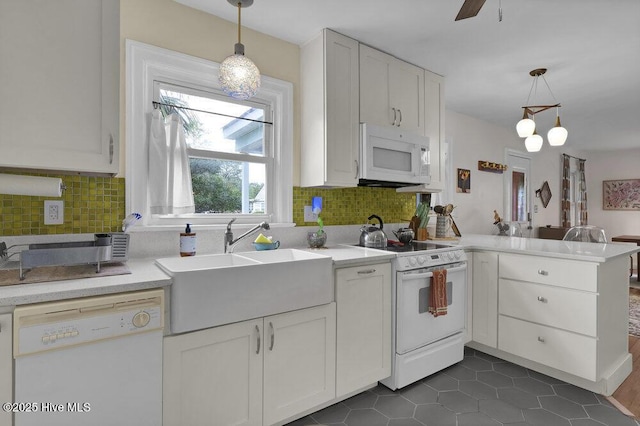 606 Ivey Cir, Wilmington, NC 28401 - kitchen with white appliances, a peninsula, light countertops, white cabinets, and backsplash