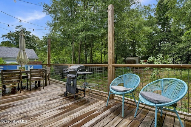 606 Ivey Cir, Wilmington, NC 28401 - wooden terrace featuring outdoor dining area, a grill, a shed, and view of wooded area
