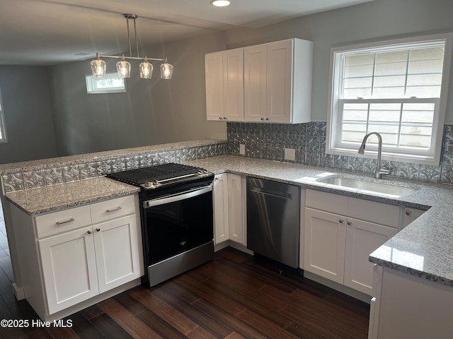 832 Fanning St, Wilmington, NC 28401 - kitchen featuring appliances with stainless steel finishes, a peninsula, dark wood-type flooring, white cabinets, and recessed lighting