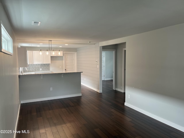 832 Fanning St, Wilmington, NC 28401 - kitchen with white cabinetry, a peninsula, a kitchen breakfast bar, dark wood-type flooring, and recessed lighting