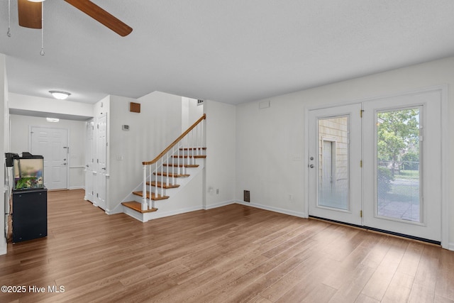 2544 Blake Trl, Wilmington, NC 28409 - unfurnished living room featuring light wood-type flooring, stairway, and a ceiling fan