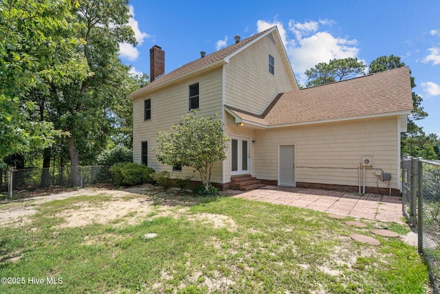 2544 Blake Trl, Wilmington, NC 28409 - back of house with entry steps, a fenced backyard, a chimney, a patio, and a shingled roof