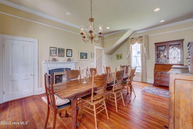 214 Nun St, Wilmington, NC 28401 - dining area with light wood-style floors, crown molding, a chandelier, a fireplace, and recessed lighting