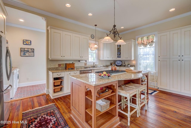 214 Nun St, Wilmington, NC 28401 - kitchen with open shelves, wood-type flooring, a kitchen island, appliances with stainless steel finishes, and a breakfast bar area