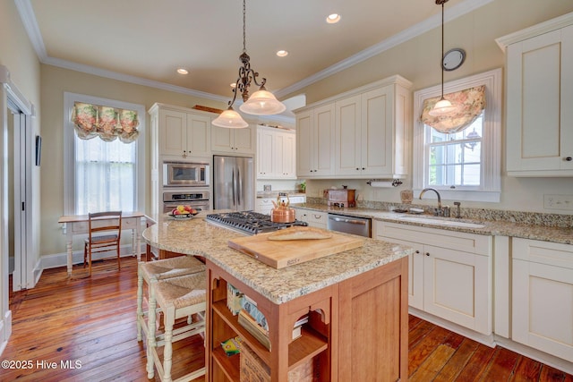 214 Nun St, Wilmington, NC 28401 - kitchen with appliances with stainless steel finishes, open shelves, a center island, crown molding, and hardwood / wood-style floors