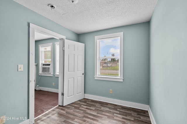 1306 Myrtle St, Greenville, NC 27834 - unfurnished bedroom featuring wood finished floors, a textured ceiling, and cooling unit