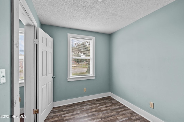 1306 Myrtle St, Greenville, NC 27834 - unfurnished bedroom with a textured ceiling and dark wood-style flooring