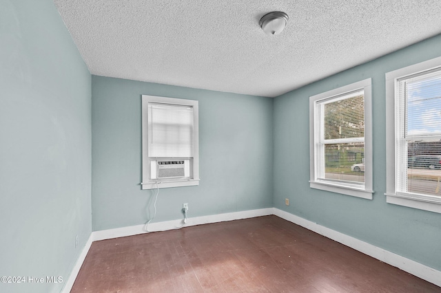 1306 Myrtle St, Greenville, NC 27834 - spare room with cooling unit, a textured ceiling, and dark wood-style flooring