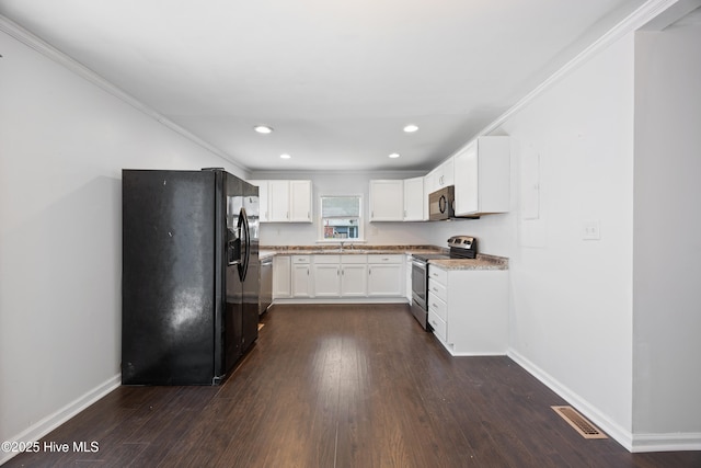 907 Woodruff Ave, Elizabeth City, NC 27909 - kitchen featuring black appliances, dark wood-type flooring, white cabinets, recessed lighting, and light stone counters