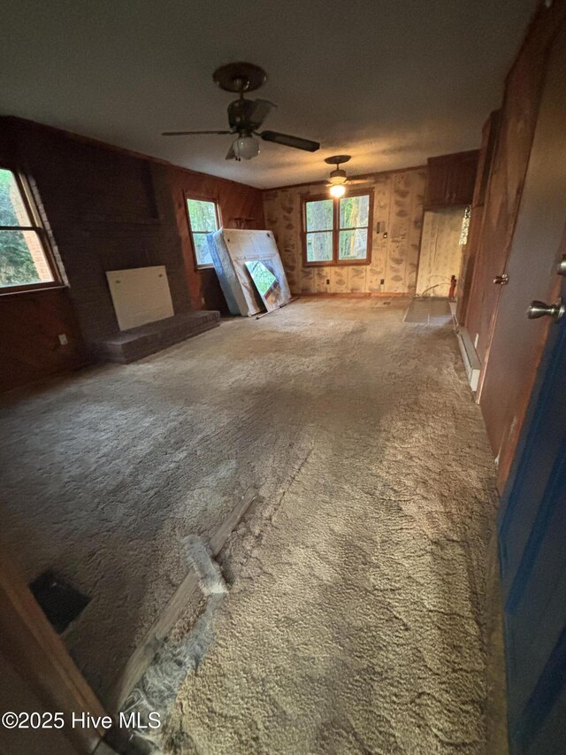 2440 Ocean Sound Cir SW, Supply, NC 28462 - unfurnished living room featuring carpet, ceiling fan, and wood walls