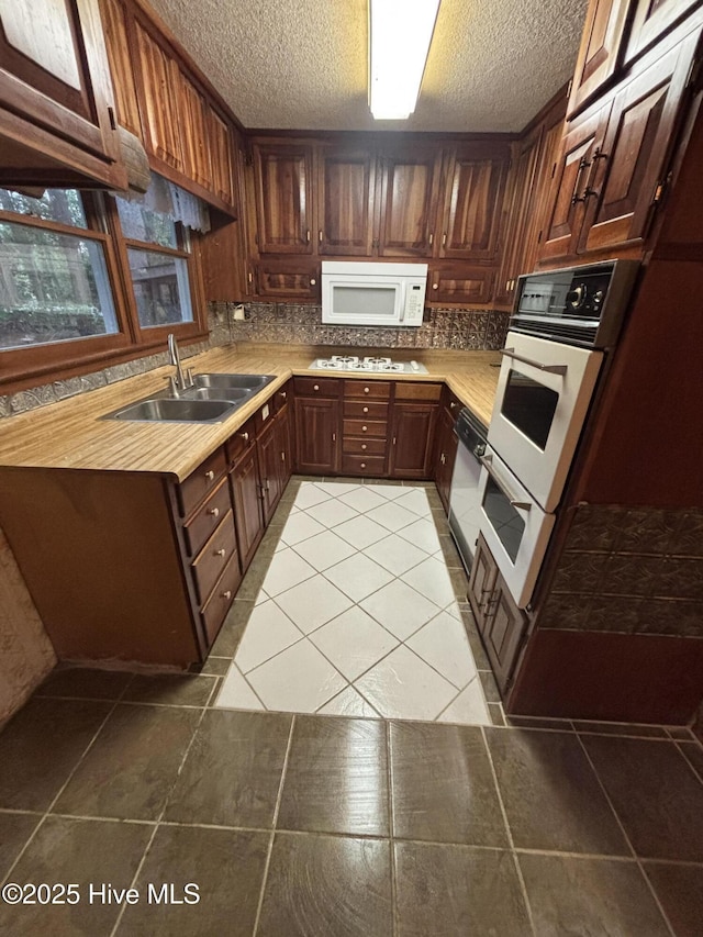 2440 Ocean Sound Cir SW, Supply, NC 28462 - kitchen featuring white appliances, light tile patterned flooring, light countertops, tasteful backsplash, and a textured ceiling
