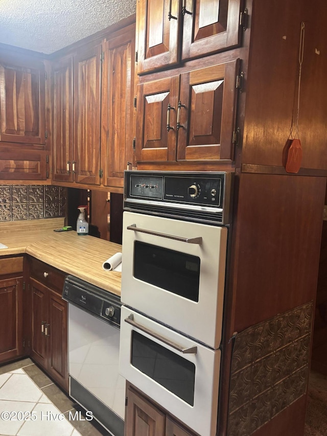 2440 Ocean Sound Cir SW, Supply, NC 28462 - kitchen featuring white appliances, light countertops, light tile patterned floors, a textured ceiling, and tasteful backsplash