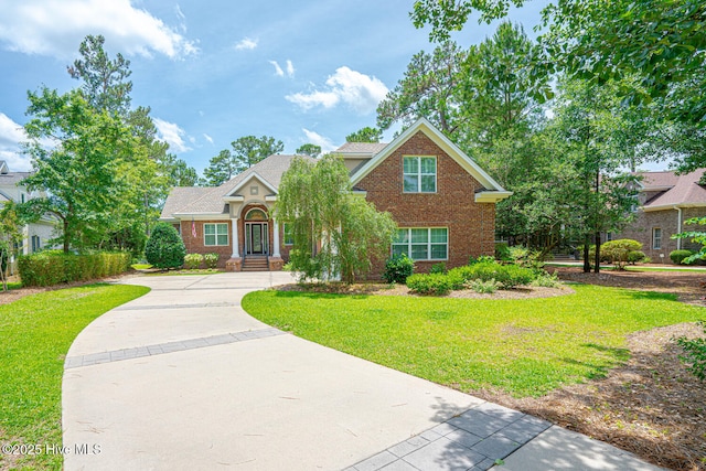 545 Gladstone Cir SW, Ocean Isle Beach, NC 28469 - view of front of home with brick siding, a front yard, and concrete driveway