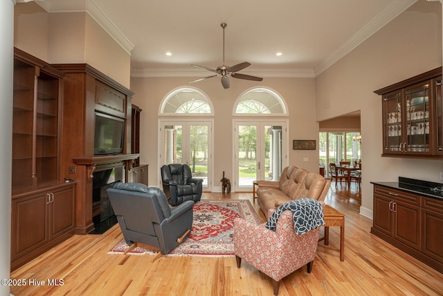545 Gladstone Cir SW, Ocean Isle Beach, NC 28469 - living room featuring light wood-style flooring, crown molding, ceiling fan, recessed lighting, and a fireplace