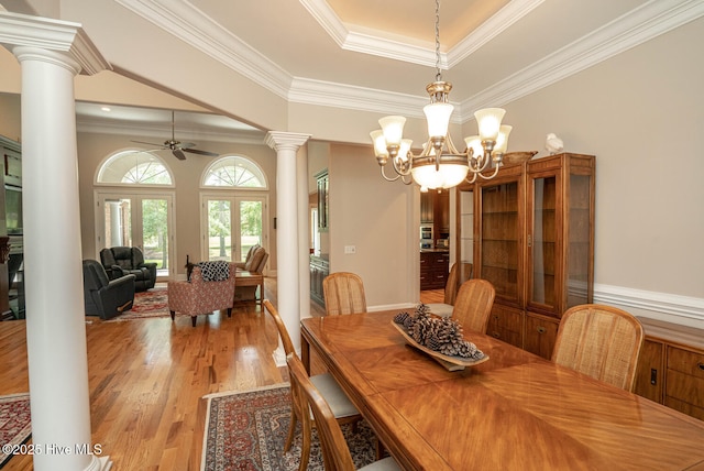 545 Gladstone Cir SW, Ocean Isle Beach, NC 28469 - dining area featuring decorative columns, a raised ceiling, wood finished floors, crown molding, and a ceiling fan