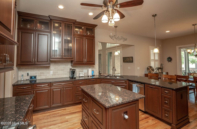 545 Gladstone Cir SW, Ocean Isle Beach, NC 28469 - kitchen featuring dishwasher, a peninsula, a center island, light wood-style flooring, and ceiling fan