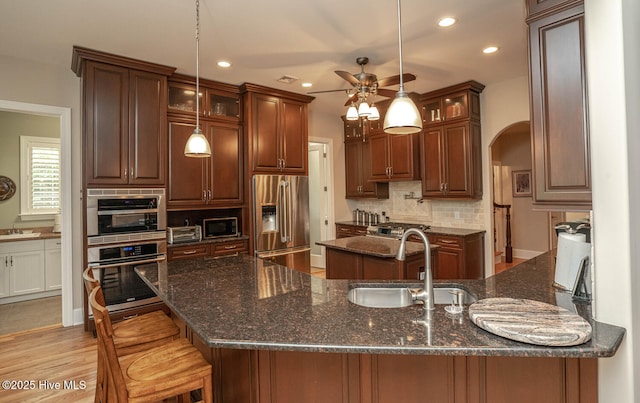 545 Gladstone Cir SW, Ocean Isle Beach, NC 28469 - kitchen featuring stainless steel appliances, ceiling fan, tasteful backsplash, glass insert cabinets, and recessed lighting
