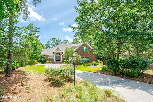 545 Gladstone Cir SW, Ocean Isle Beach, NC 28469 - traditional home featuring brick siding, concrete driveway, and a front lawn