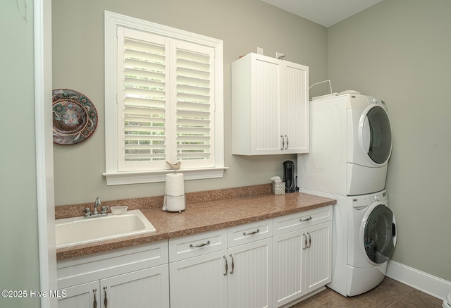 545 Gladstone Cir SW, Ocean Isle Beach, NC 28469 - washroom featuring stacked washer / dryer, cabinet space, and tile patterned floors