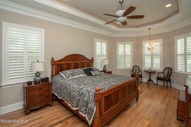 545 Gladstone Cir SW, Ocean Isle Beach, NC 28469 - bedroom featuring light wood-style floors, a raised ceiling, ornamental molding, a chandelier, and a ceiling fan