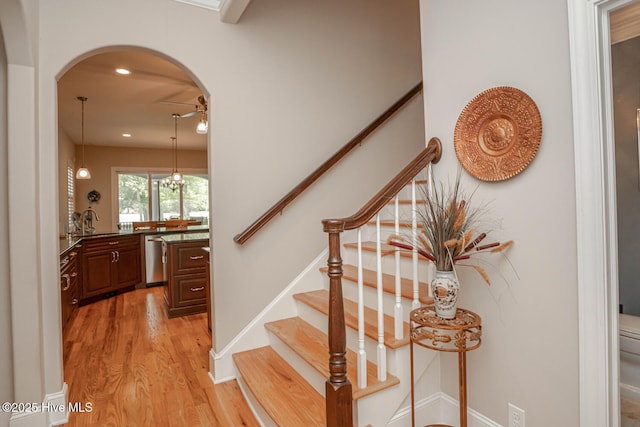 545 Gladstone Cir SW, Ocean Isle Beach, NC 28469 - stairway featuring wood finished floors, arched walkways, and recessed lighting