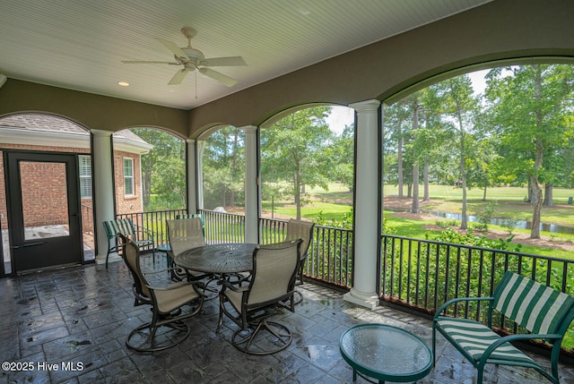 545 Gladstone Cir SW, Ocean Isle Beach, NC 28469 - sunroom with ceiling fan, a water view, view of wooded area, and outdoor dining space