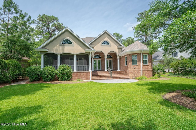 545 Gladstone Cir SW, Ocean Isle Beach, NC 28469 - view of front facade featuring a front yard, stucco siding, and brick siding