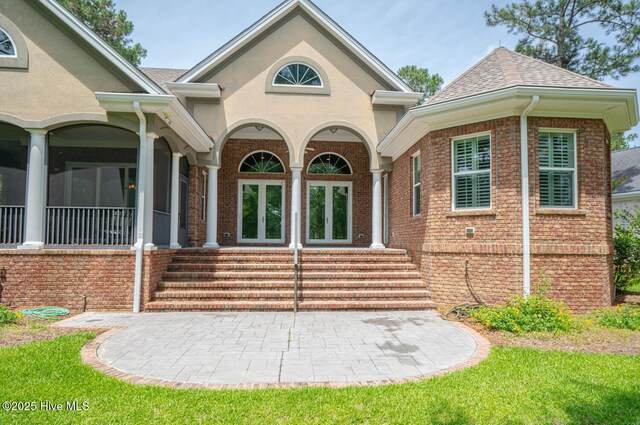 545 Gladstone Cir SW, Ocean Isle Beach, NC 28469 - view of front of home with brick siding, french doors, and a shingled roof