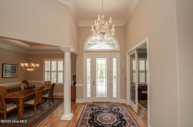 545 Gladstone Cir SW, Ocean Isle Beach, NC 28469 - foyer entrance featuring a chandelier, light wood-style flooring, ornamental molding, decorative columns, and a high ceiling