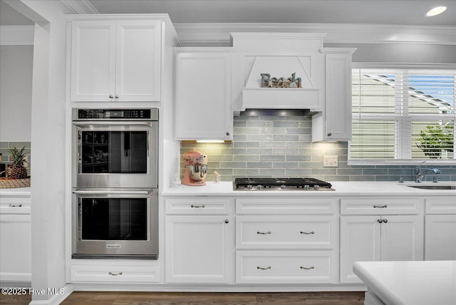 3236 Penzance Row, Wilmington, NC 28412 - kitchen featuring appliances with stainless steel finishes, crown molding, white cabinets, tasteful backsplash, and light countertops