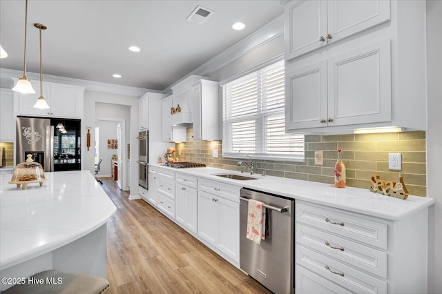 3236 Penzance Row, Wilmington, NC 28412 - kitchen featuring stainless steel appliances, crown molding, pendant lighting, light wood finished floors, and white cabinets
