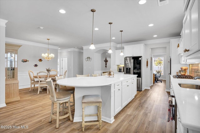 3236 Penzance Row, Wilmington, NC 28412 - kitchen featuring stainless steel fridge, light wood-style floors, a center island with sink, recessed lighting, and crown molding