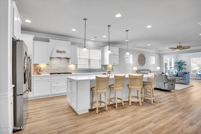 3236 Penzance Row, Wilmington, NC 28412 - kitchen featuring freestanding refrigerator, gas stovetop, crown molding, white cabinets, and tasteful backsplash