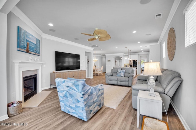 3236 Penzance Row, Wilmington, NC 28412 - living area with light wood-type flooring, ceiling fan, a fireplace with flush hearth, crown molding, and recessed lighting