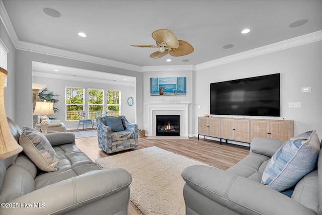 3236 Penzance Row, Wilmington, NC 28412 - living area featuring wood finished floors, ceiling fan, recessed lighting, a glass covered fireplace, and ornamental molding