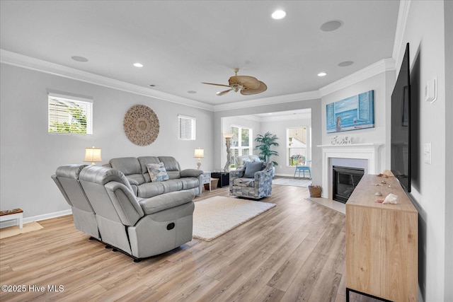 3236 Penzance Row, Wilmington, NC 28412 - living area with crown molding, light wood-type flooring, a ceiling fan, healthy amount of natural light, and a glass covered fireplace