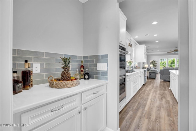 3236 Penzance Row, Wilmington, NC 28412 - kitchen with open floor plan, light wood-style flooring, decorative backsplash, recessed lighting, and white cabinetry