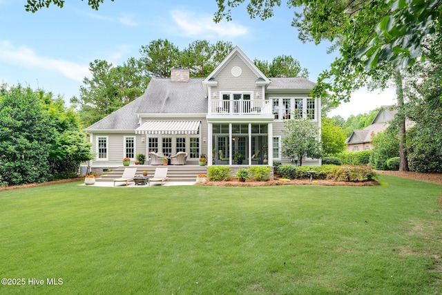 220 October Glory Dr, Wallace, NC 28466 - back of house with a yard, a balcony, a shingled roof, a patio, and a chimney