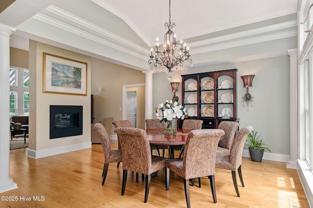 220 October Glory Dr, Wallace, NC 28466 - dining room featuring decorative columns, light wood-type flooring, a glass covered fireplace, a chandelier, and lofted ceiling