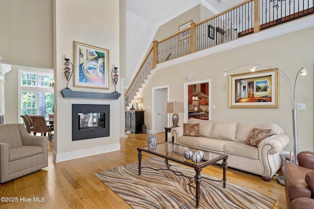 220 October Glory Dr, Wallace, NC 28466 - living area with a towering ceiling, a multi sided fireplace, wood finished floors, and stairs