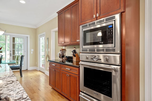 220 October Glory Dr, Wallace, NC 28466 - kitchen with stainless steel appliances, light wood finished floors, crown molding, brown cabinetry, and light stone countertops