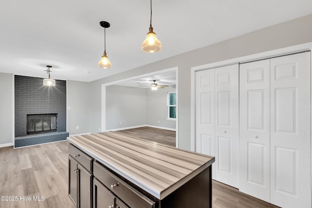 411 Cardinal Dr, Jacksonville, NC 28546 - kitchen with hanging light fixtures, light wood finished floors, open floor plan, a ceiling fan, and a brick fireplace