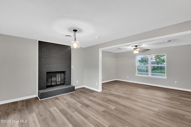 411 Cardinal Dr, Jacksonville, NC 28546 - unfurnished living room featuring wood finished floors, a ceiling fan, and a brick fireplace