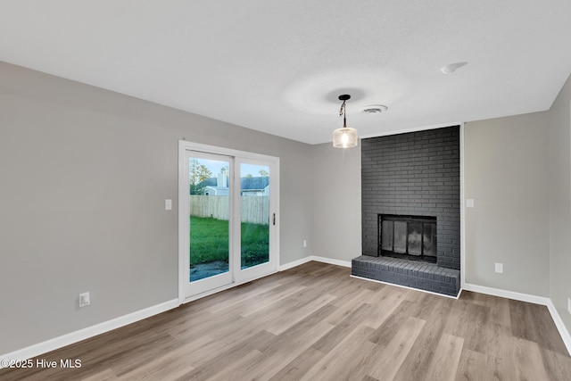 411 Cardinal Dr, Jacksonville, NC 28546 - unfurnished living room featuring wood finished floors and a brick fireplace