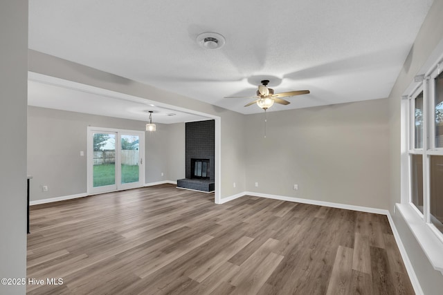 411 Cardinal Dr, Jacksonville, NC 28546 - unfurnished living room with a ceiling fan, wood finished floors, and a fireplace