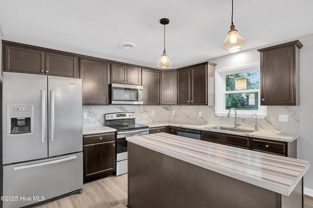 411 Cardinal Dr, Jacksonville, NC 28546 - kitchen featuring stainless steel appliances, dark brown cabinets, light countertops, and light wood-style floors