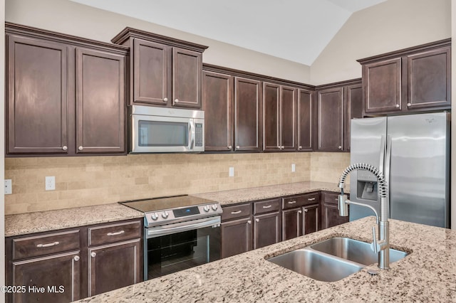 707 Liberty Landing Way, Wilmington, NC 28409 - kitchen featuring stainless steel appliances, dark brown cabinetry, vaulted ceiling, and backsplash