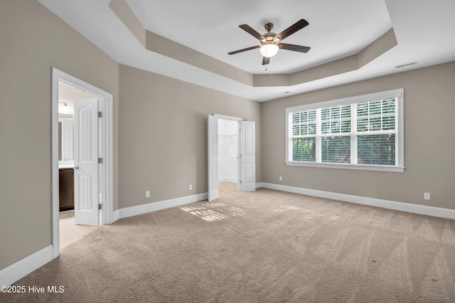 707 Liberty Landing Way, Wilmington, NC 28409 - unfurnished bedroom featuring carpet floors, a raised ceiling, a walk in closet, ensuite bathroom, and ceiling fan