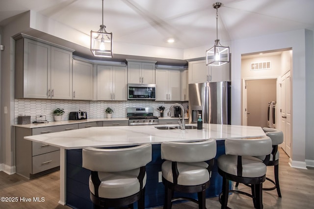 440 Bramble Ln, Clayton, NC 27527 - kitchen with appliances with stainless steel finishes, gray cabinets, wood finished floors, decorative backsplash, and recessed lighting